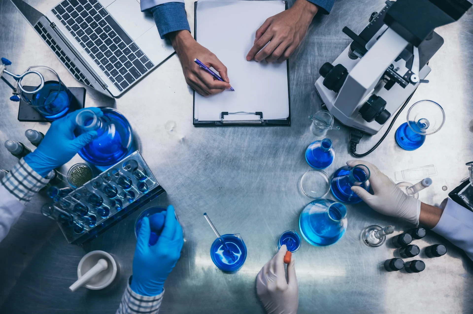 top-view-workspace-laboratory-with-microscope-laptop-laboratory-tools-min-1920x1277